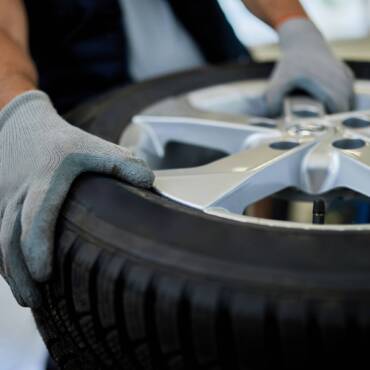 closeup-mechanic-working-with-car-tire-auto-repair-shop-scaled.jpg